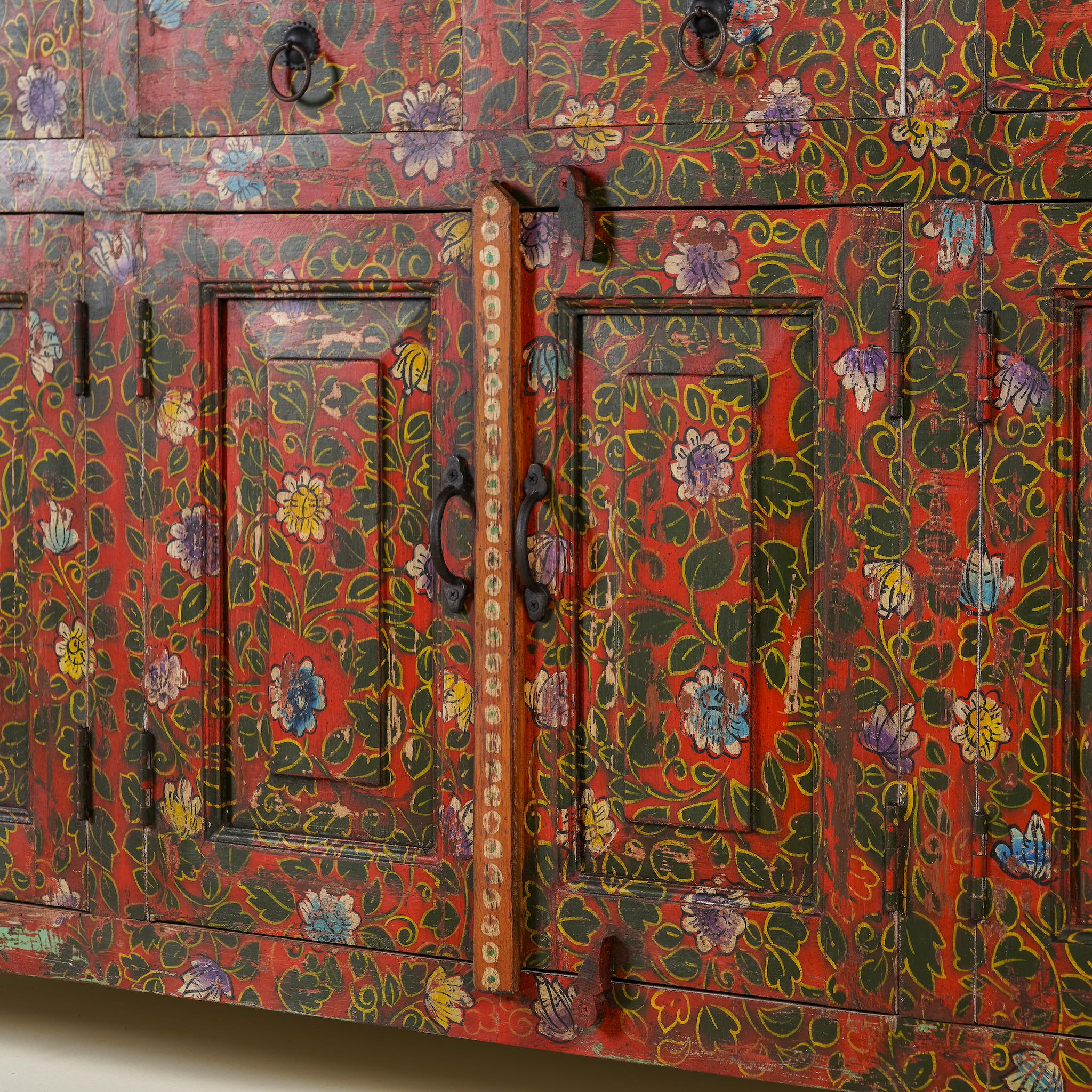 Close up image of a door of a hand painted sideboard made of reclaimed wood in boho design with ample storage.