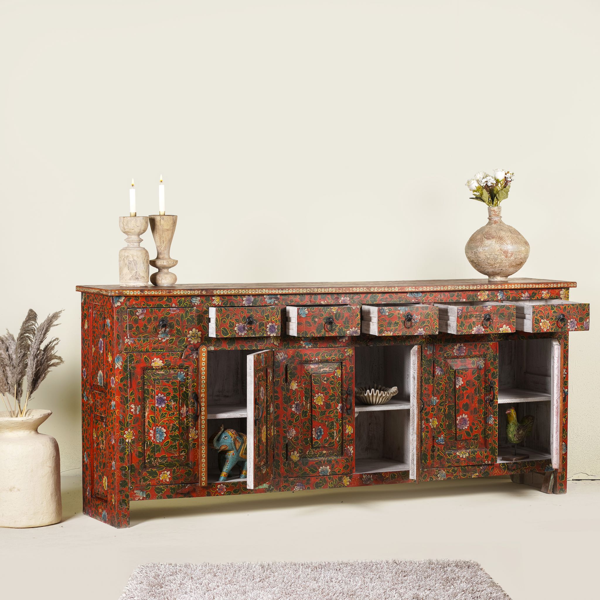 Side angle image with open doors of a of a hand painted sideboard made of reclaimed wood in boho design with ample storage.