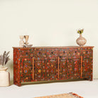 Side angle image of a of a hand painted sideboard made of reclaimed wood in boho design with ample storage.