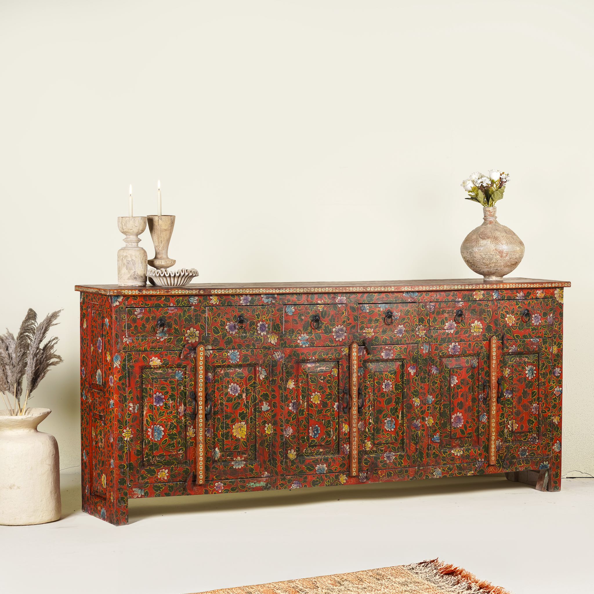 Side angle image of a of a hand painted sideboard made of reclaimed wood in boho design with ample storage.