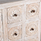 Close up image of a Varnika white-washed mango wood sideboard with hand-carved front, six small drawers and two doors, 180x50x85cm