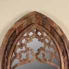 Close up image of a Veda hand carved mango wood arch mirror with decorative openwork frame and natural mango finish, 85x15x197cm