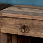 Close up image of a reclaimed wood bedside table with drawer and open shelf – handcrafted driftwood furniture designed for rustic minimalism and natural interiors.