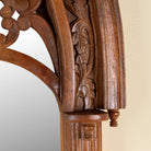 Close up image of a Veeksha hand carved mango wood arch mirror with decorative openwork frame in teak wood finish, 85x15x197cm