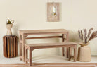 Side angle image of a Vintage school bench set from India, crafted from old teak wood, featuring a simple, sturdy design with a long bench and matching table in a natural, weathered finish, styled in a neutral-toned interior with rustic decor accents.
