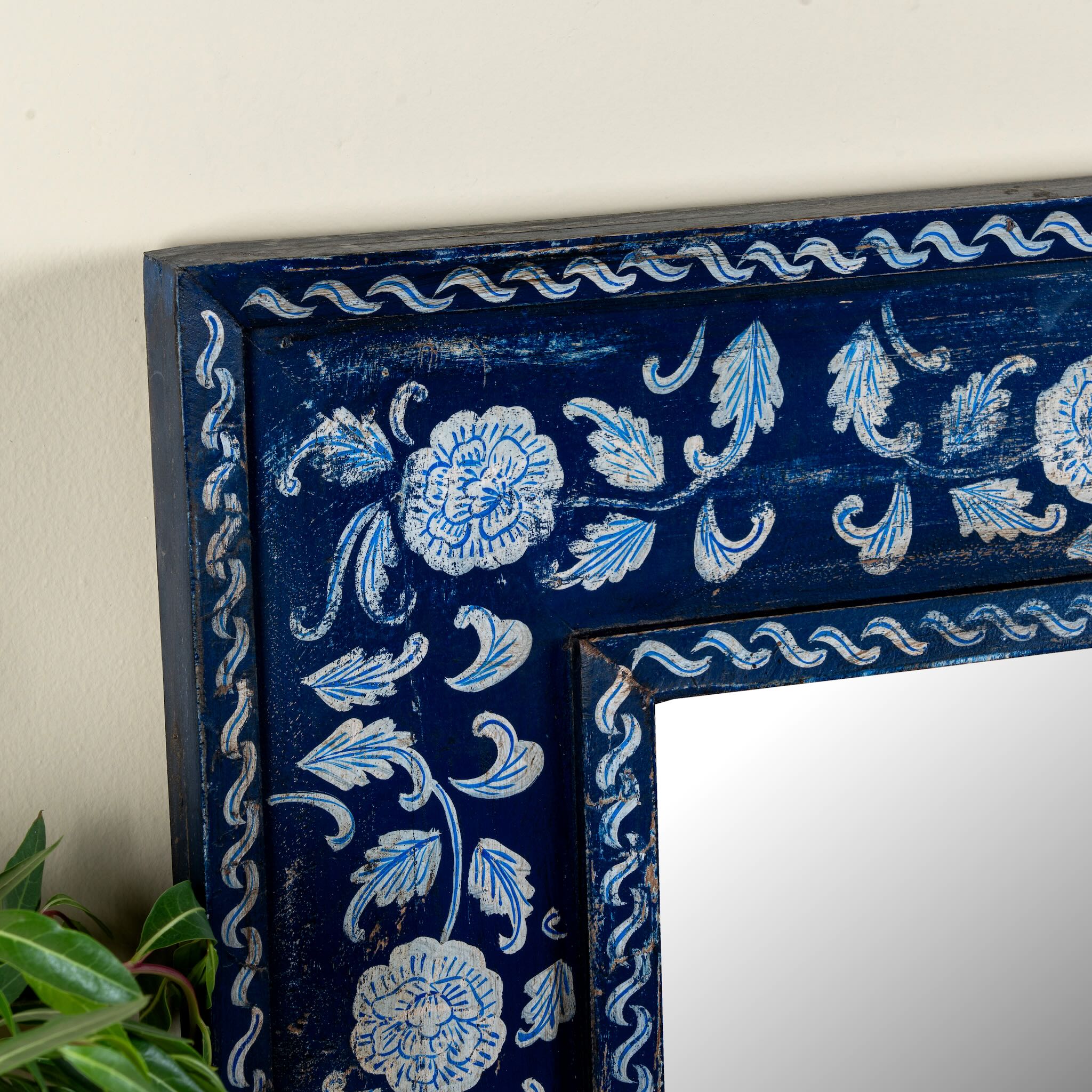 Close up image of a Vihana hand-painted reclaimed wood wall mirror with deep blue floral frame, artisan detailing, and vintage Indian character, 90x90cm.