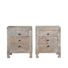 White background image of a pair of hand-carved mango wood nightstands Vikram with three drawers each, showcasing intricate floral motifs in a distressed vintage-style finish. Elegant and functional bedside tables with timeless artisan appeal.