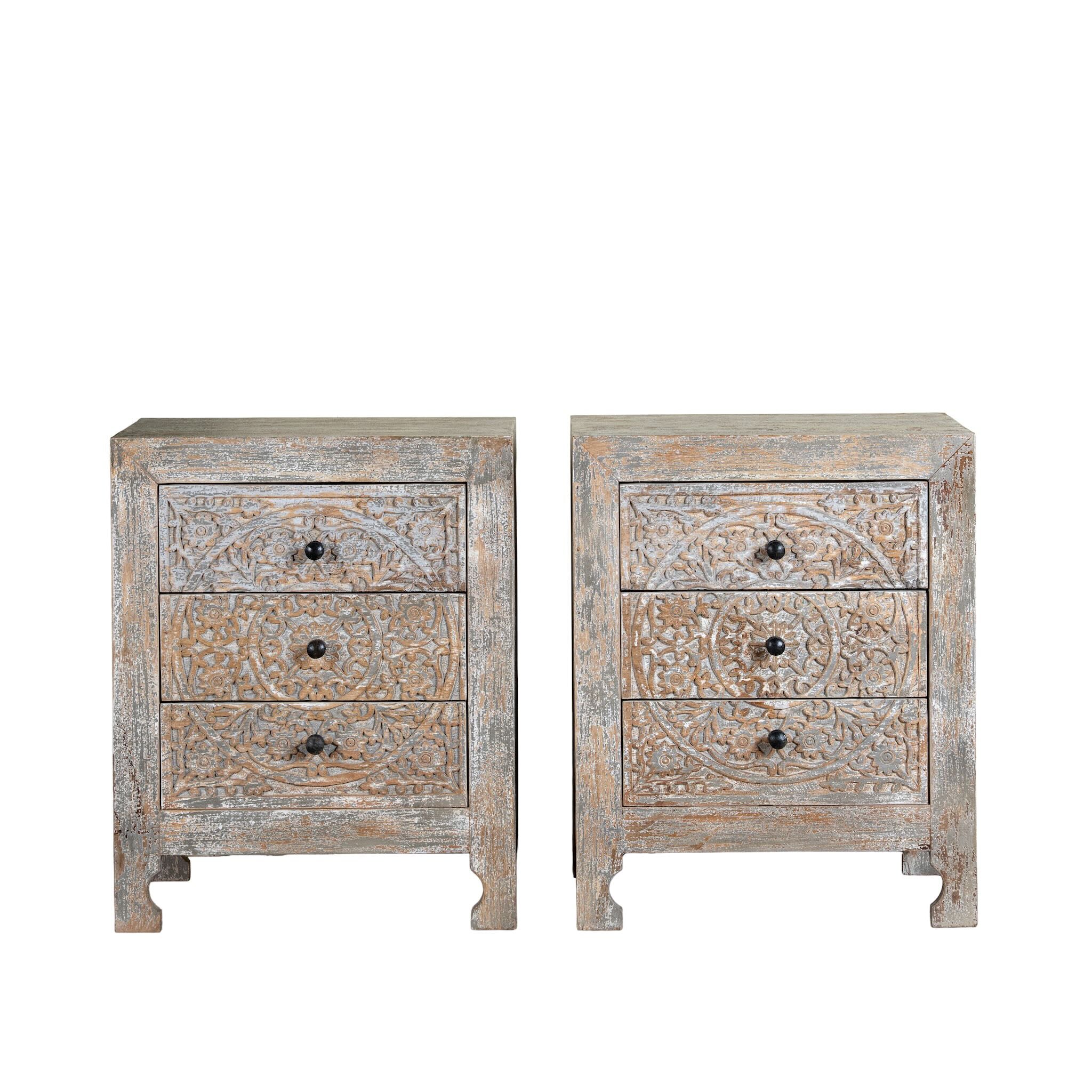 White background image of a pair of hand-carved mango wood nightstands Vikram with three drawers each, showcasing intricate floral motifs in a distressed vintage-style finish. Elegant and functional bedside tables with timeless artisan appeal.