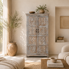 Lifestyle imagination of a hand-carved mango wood cabinet Ava in a vintage distressed finish with floral motifs. A stylish piece of mango wood furniture and vintage home accessory with practical storage and timeless charm.