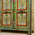 Close up image of the leg part of a reclaimed wood sideboard with hand painted floral motifs and distressed finish; artisanal storage furniture for bohemian interiors, 170 × 40 × 104 cm.