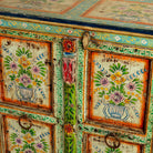 Close up image of a reclaimed wood sideboard with hand painted floral motifs and distressed finish; artisanal storage furniture for bohemian interiors, 170 × 40 × 104 cm.
