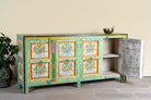 Side angle image with open door of a reclaimed wood sideboard with hand painted floral motifs and distressed finish; artisanal storage furniture for bohemian interiors, 170 × 40 × 104 cm.