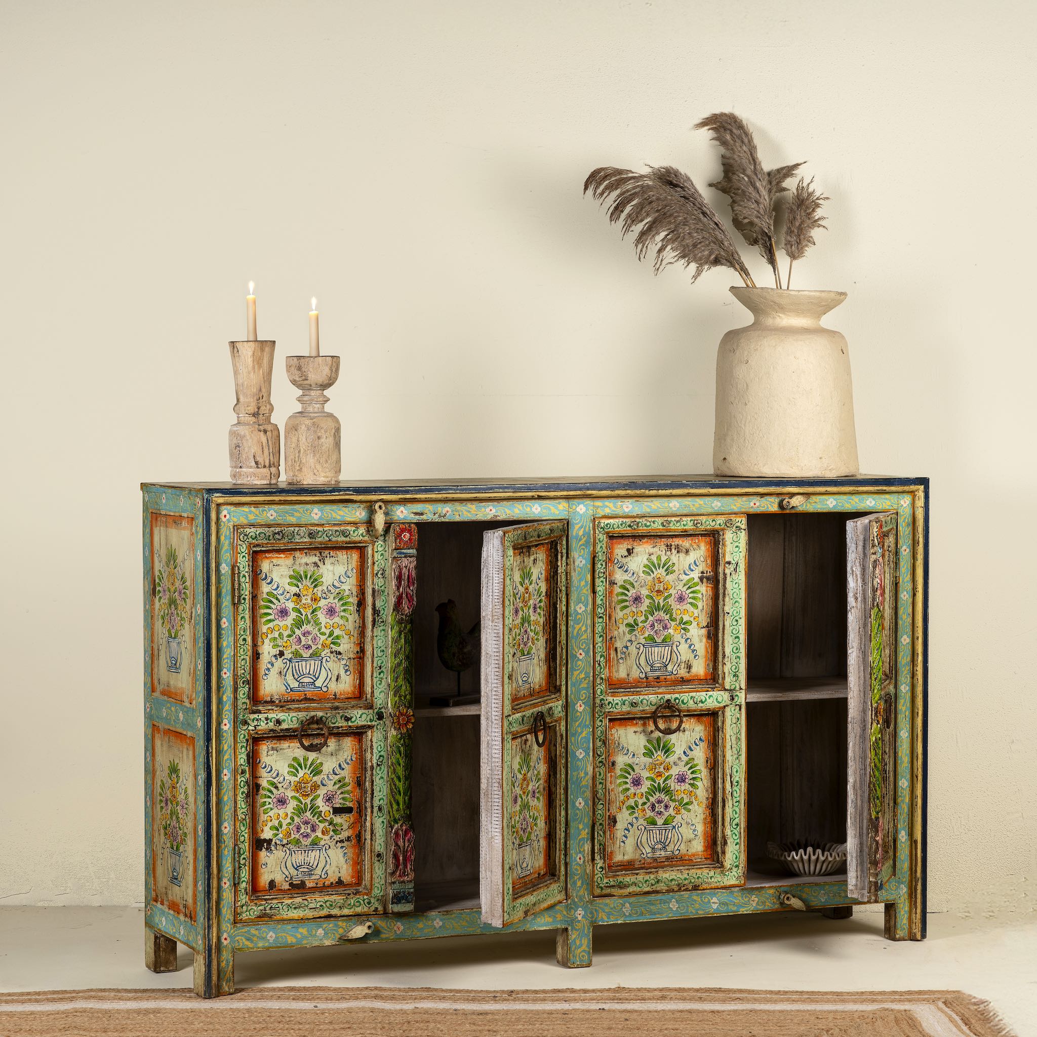 Open door image of a reclaimed wood sideboard with hand painted floral motifs and distressed finish; artisanal storage furniture for bohemian interiors, 170 × 40 × 104 cm.