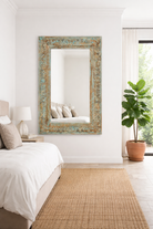 Lifestyle imagination of a carved mango wood mirror Animisha with turquoise finish and floral hand-carving. A statement piece for vintage home decor and Indian-inspired interiors.