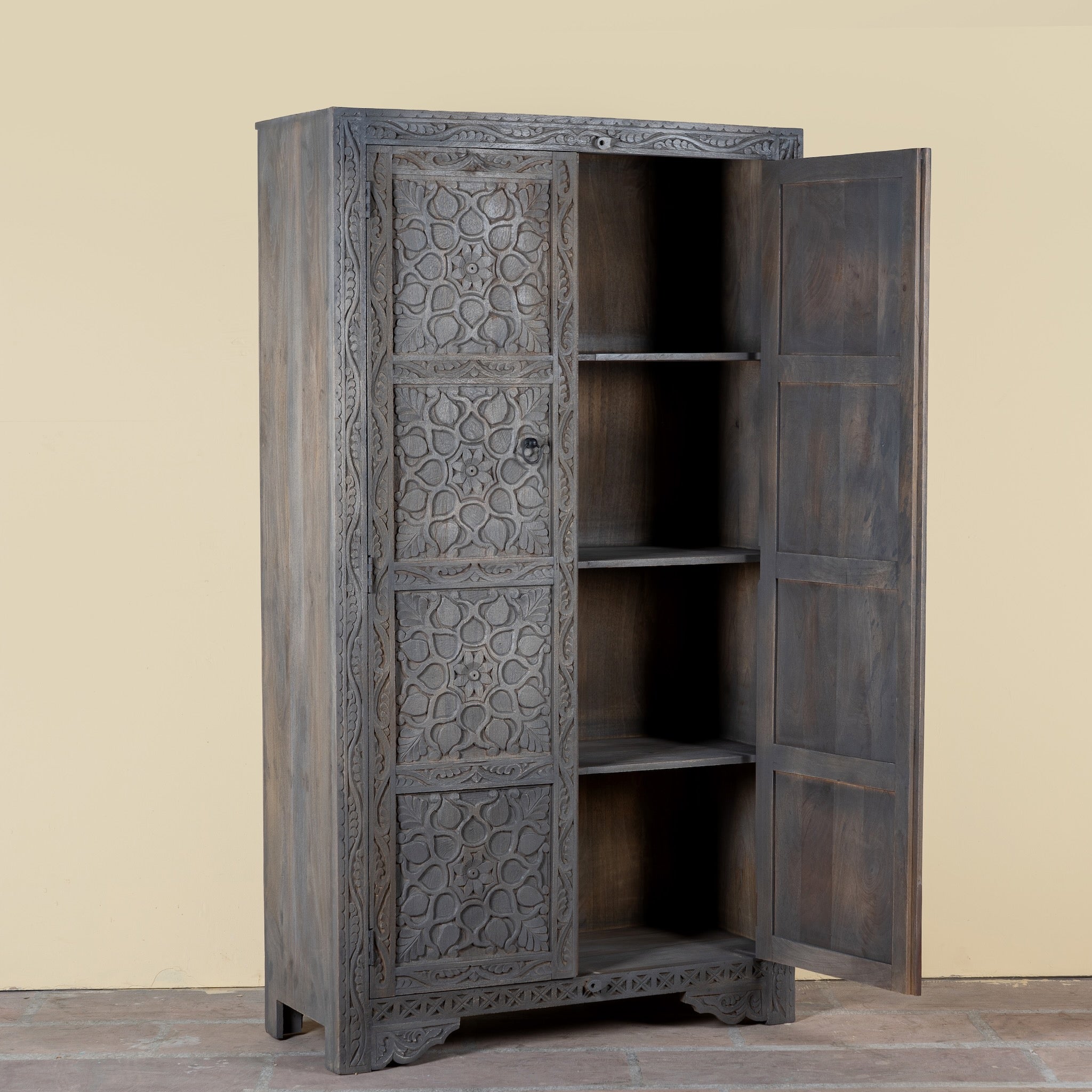 Side angle image with open door of a Vishyali hand carved grey mango wood wardrobe with geometric carved doors 180cm
