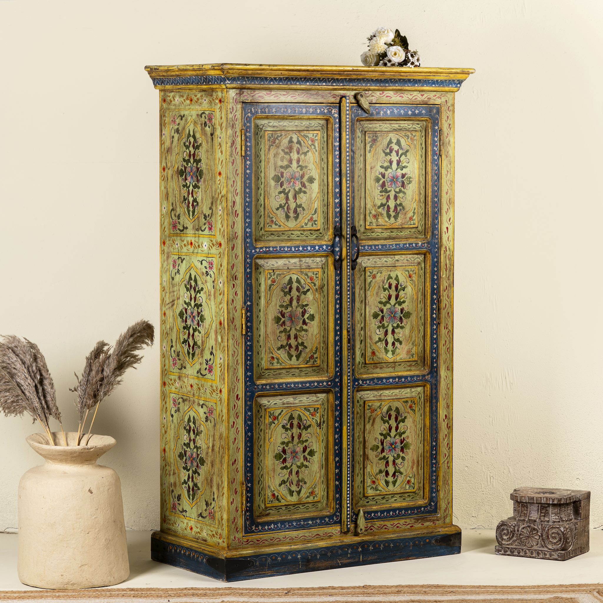 Side angle image of a hand painted wardrobe made from reclaimed wood with floral motifs and distressed finish; ideal for a boho chic living room or eclectic bedroom, 90 × 40 × 150 cm.