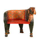 White background image of a elephant-shaped armchair crafted from reclaimed wood, featuring intricate hand-painted details in vibrant red, orange, green, and multi coloured floral patterns, with sculpted elephant head and legs for a whimsical, artistic touch.
