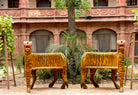 Life style image of two hand-painted tiger chairs made from recycled teak wood with carved tiger motif; ideal for a boho chic living room, 87 × 75 × 96 cm.