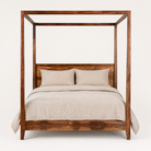 Image of a handcrafted mango wood canopy bed with minimalist four-poster design, boho bed 180 × 200 cm, bedroom furniture in rustic Mediterranean style.