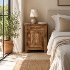 Lifestyle image of a image of a Yana set of two hand carved mango wood bedside tables with drawer and cupboard 65cm