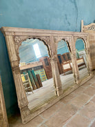 Original image of a Arched wooden mirror Yosha made from an antique Indian teak window frame with triple arches and carved columns. A piece of unique Indian furniture with bold scale and rustic heritage charm.