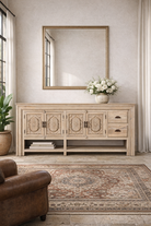 Lifestyle imagination of a hand-carved mango wood console table Zahira with 2 drawers and 4 doors in a natural finish. Elegant living room furniture piece with artistic detailing and practical storage.
