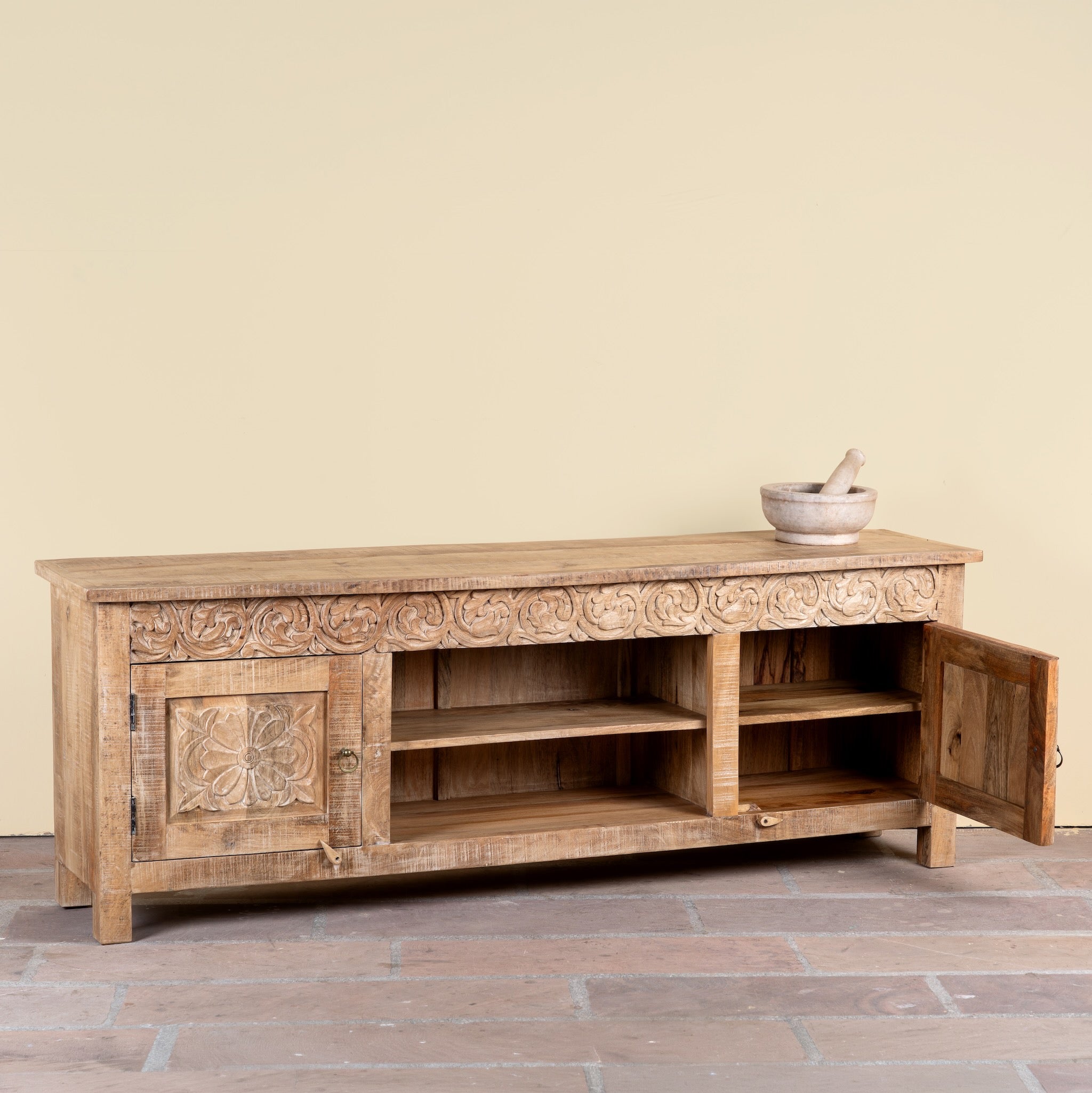 Side angle image with open door of a Zarina hand carved mango wood TV unit with floral carved doors 180cm