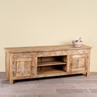 Side angle image of a Zarina hand carved mango wood TV unit with floral carved doors 180cm