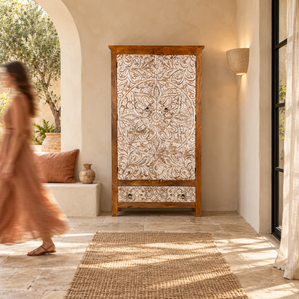 Lifestyle image of a Hand-carved mango wood wardrobe with whitewashed floral motifs – Zashil by Om Home & Garden, a Mediterranean-inspired piece of carved wooden furniture.