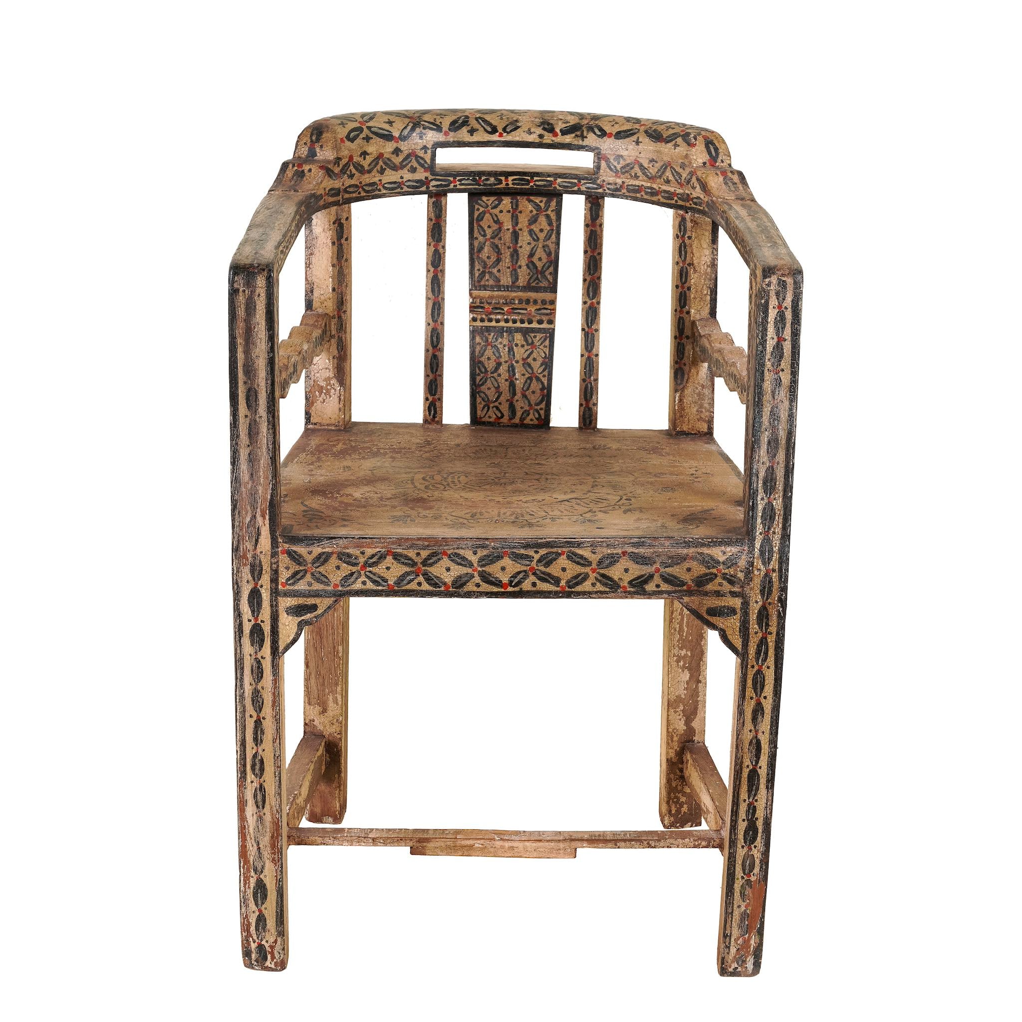 White background image of a hand-painted armchair crafted from reclaimed teak wood, featuring intricate traditional patterns in earthy tones on the backrest, seat, and frame, with a rustic and vintage finish.
