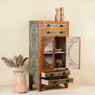 Open door view of a hand-painted showcase cabinet made from mango wood, featuring a circular glass-front display, floral motifs in rich orange, green, and red tones, and five drawers for added storage.

