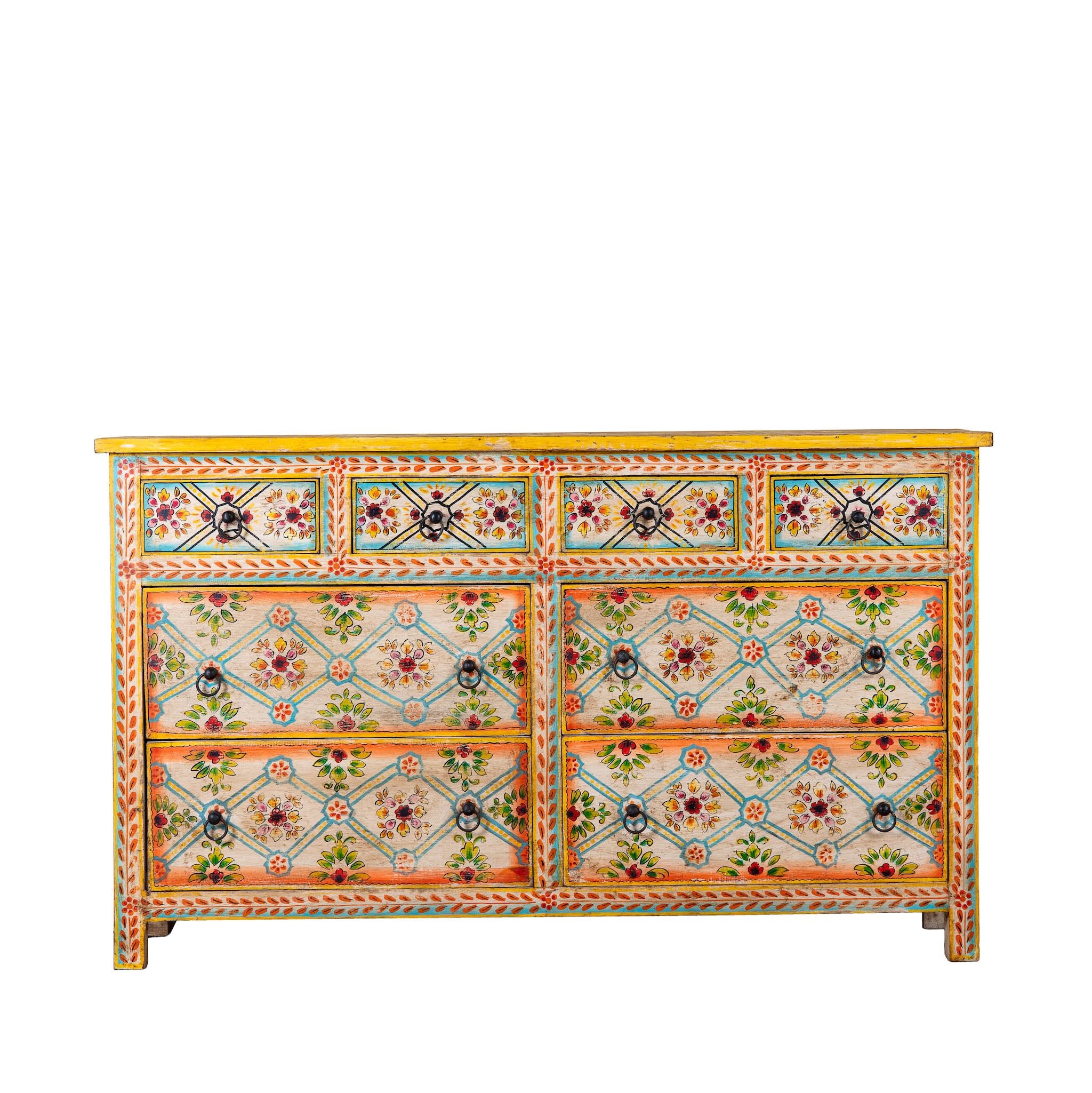 White background image of a Ziya hand‑painted chest of 8 drawers made from reclaimed wood with floral motifs and iron handles—an artisan piece of painted wooden furniture.
