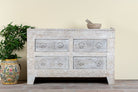 Handcrafted chest of drawers Zuber made from reclaimed wood, featuring four carved drawers with circular motifs and a whitewashed finish. A rustic, sustainable furniture piece with soft texture and elegant detailing.