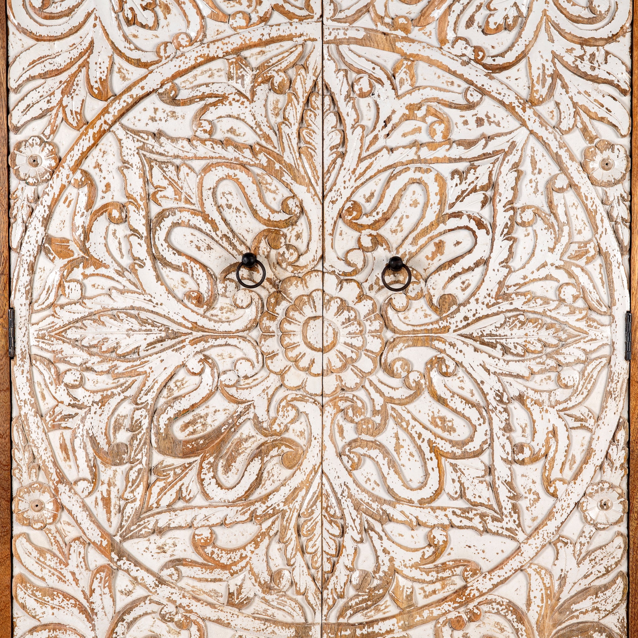 Close up image of a hand-carved mango wood wardrobe with whitewashed floral motifs – Zashil by Om Home & Garden, a Mediterranean-inspired piece of carved wooden furniture.