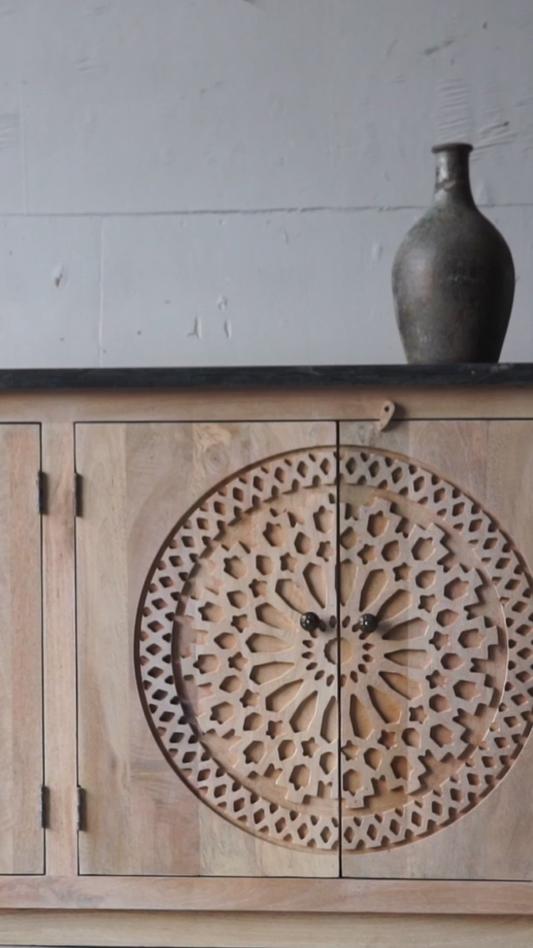 Short movie of a handcrafted acacia wood sideboard with black marble top and ornate hand-carved doors – a luxurious piece of wood carved furniture.