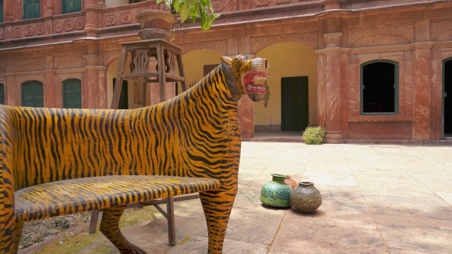 Reel showing two hand-painted tiger chairs made from recycled teak wood with carved tiger motif; ideal for a boho chic living room, 87 × 75 × 96 cm.