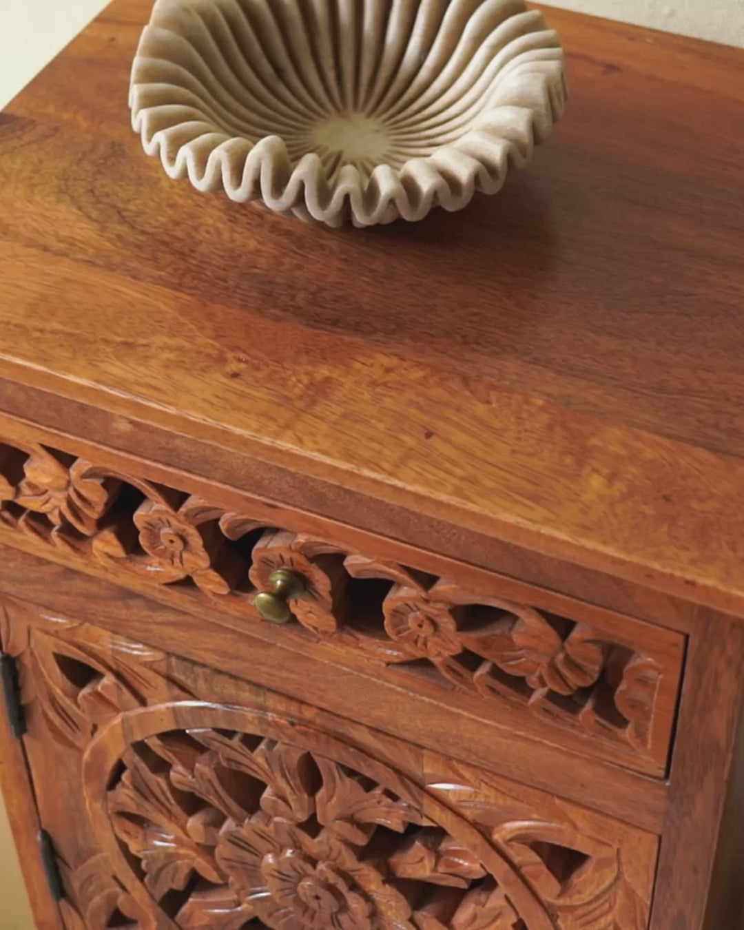 Reel showing a pair of mango wood night stands with hand carved floral and geometric detailing, warm teak finish; elegant hand carved furniture, 45 × 35 × 65 cm.