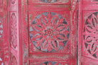 Close up image of a hand-carved pink mango wood folding room divider with delicate carved patterns, natural variations, and warm boho style for unique interiors.