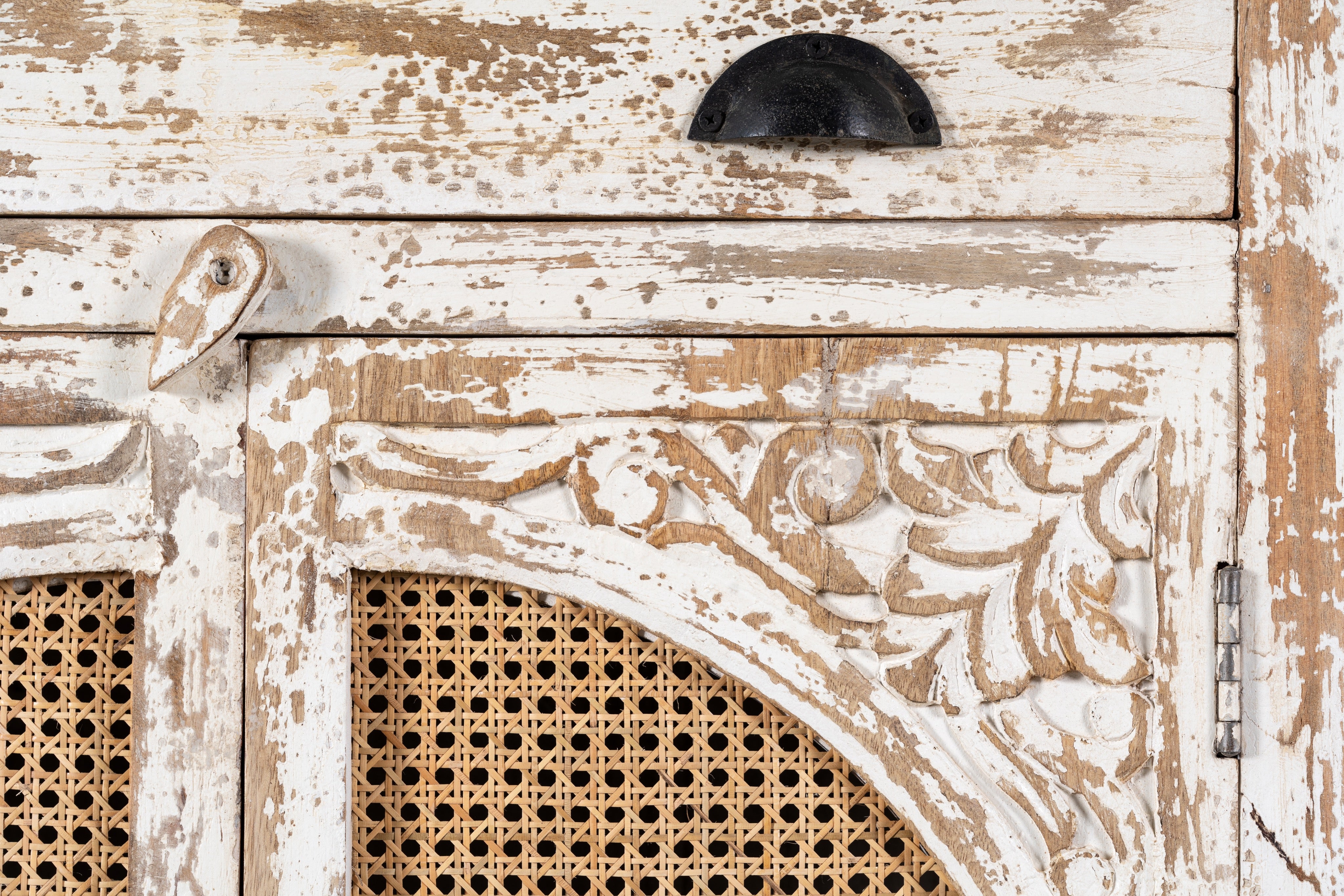 Close up image of a Ahalya handcrafted solid mango wood cabinet with hand-carved floral doors, natural rattan inserts, four drawers, two storage compartments, and Mediterranean-inspired design, 148cm.