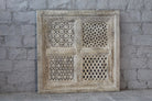 Square mango wood wall panel Akupara with intricate hand-carved detailing in soft, natural tones. A piece of unique wooden wall art perfect for wood wall decoration and carved wood furniture collections.