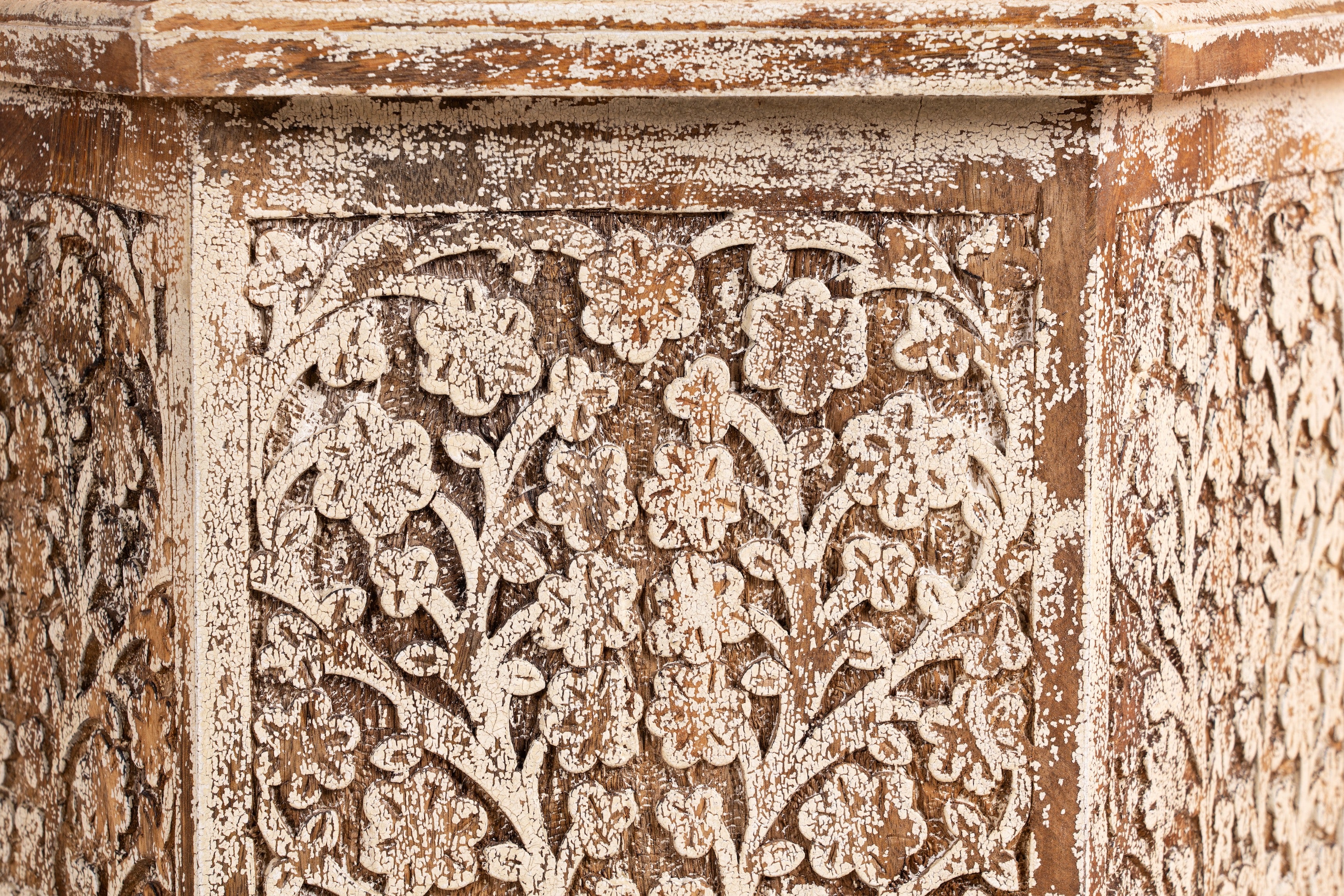 Close up image of a Amreli antique white coffee table made of mango wood, hand carved.