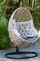 Side angle image of a Anandh grey wicker hanging egg chair with stand and cushions 180cm