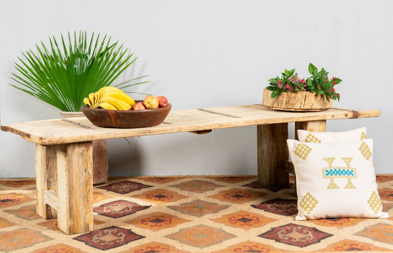 Side angle image of a Beas handcrafted bench made from a reclaimed antique Indian half teak door with original iron fittings, solid teak wood construction, rustic Ibiza style, and versatile bench or table design, 170cm.