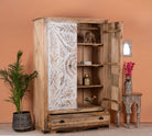 Side angle image with open door of a Cheyyur handcrafted solid mango wood wardrobe with hand-carved whitewashed doors, large storage drawer, traditional Indian detailing, and natural wood grain, 190cm.