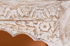 Close up image of a Dhola handcrafted solid mango wood coffee table with intricately hand-carved floral patterns, natural wood grain, and artisan craftsmanship, 120cm.