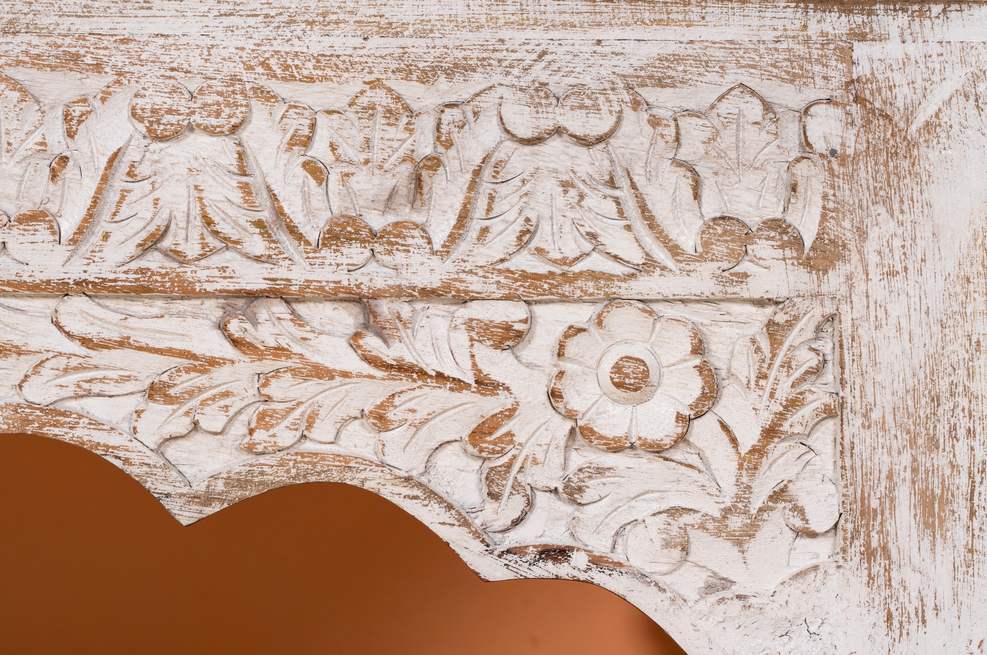 Close up image of a Dhola handcrafted solid mango wood coffee table with intricately hand-carved floral patterns, natural wood grain, and artisan craftsmanship, 120cm.