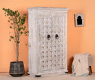 Side angle image of a handcrafted cabinet made from reclaimed wood with white-washed finish and Indian carvings – sustainable furniture and unique Indian furniture with cultural depth.