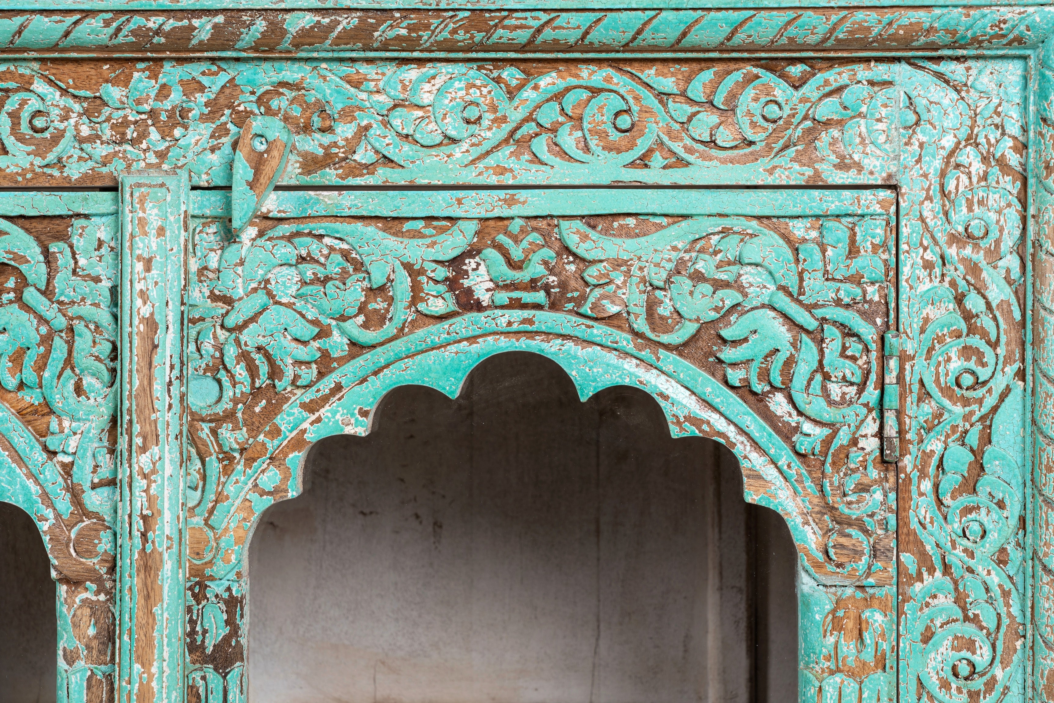 Close up image of Jesar handcrafted turquoise-washed carved wooden sideboard with Indian motifs and open compartments; ideal as living room furniture or carved showcase, 180 × 100 × 40 cm.
