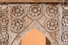 Close up image of a hand carved mango wood coffee table with floral pattern, striking layered colour and vintage charm. A unique wooden accent for your home.