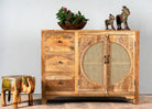 Image with a hand carved mango wood cabinet in natural finish with 3 drawers and 2 rattan doors.